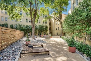 a courtyard with a picnic table and a bench in front of a building
